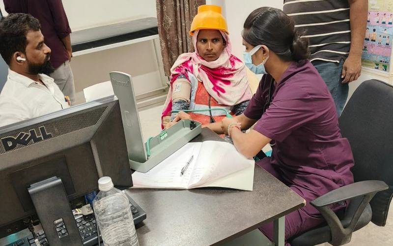 A clinician examining a patient at a camp registration desk