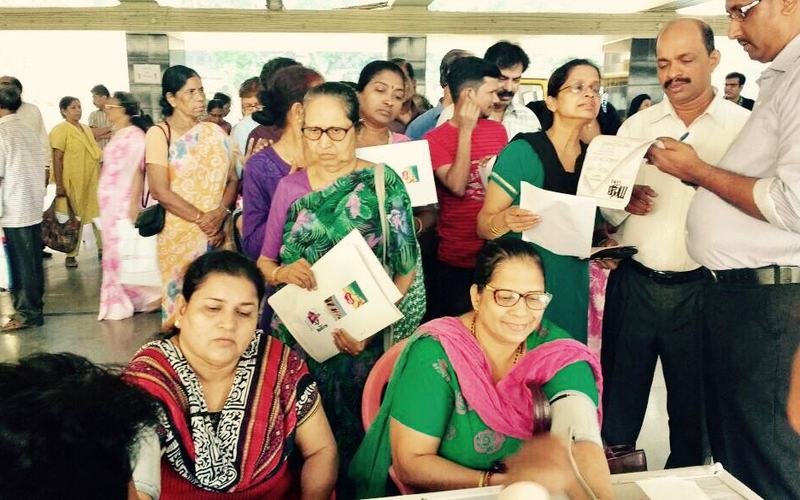 Attendees reading health information leaflets at a camp